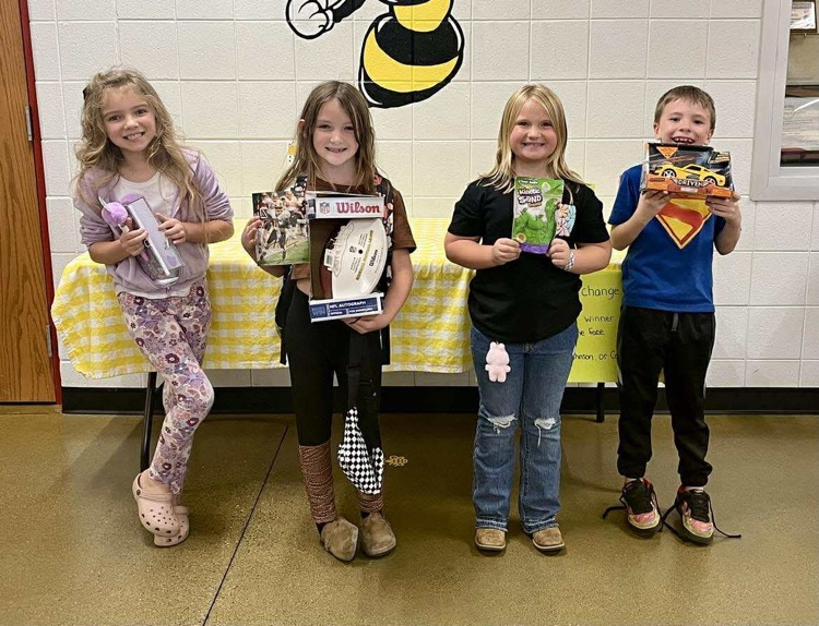 Four students holding prizes 
