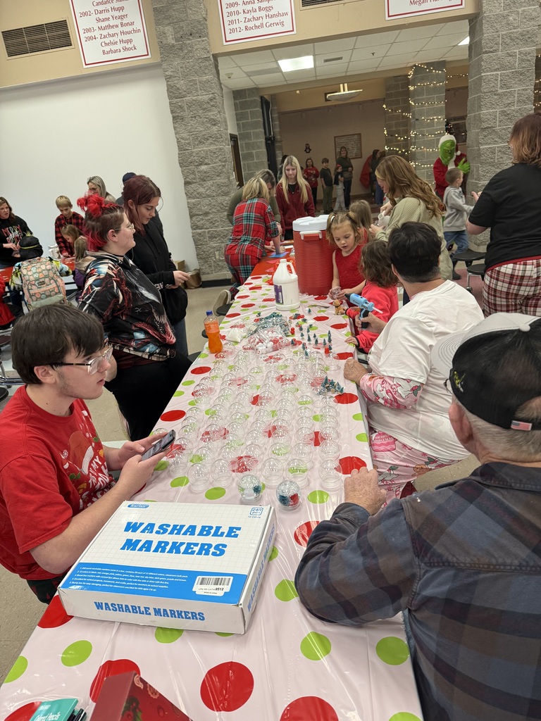  Families seated at decorated tables enjoying pancakes and conversation.