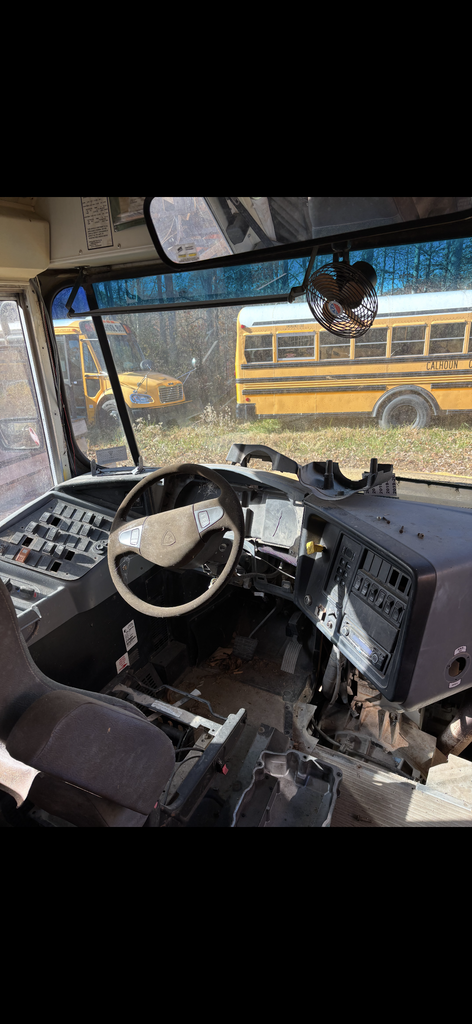 Inside view of bus 24 driver's seat, steering wheel, dash and windshield