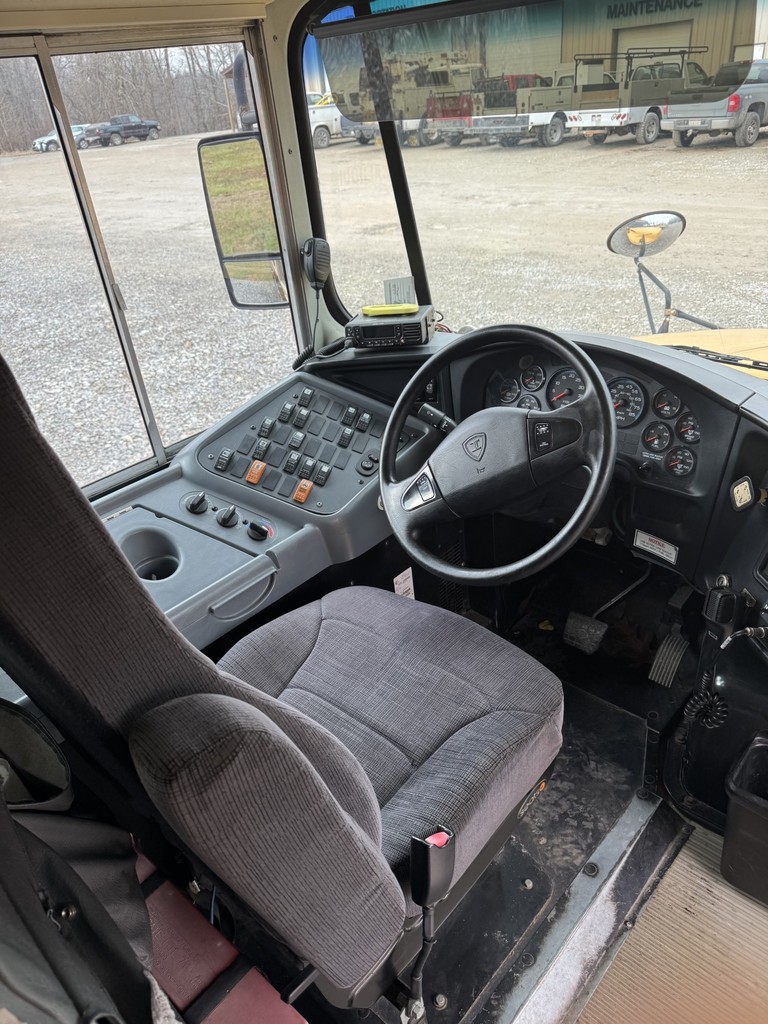 Inside view of bus 16 driver's seat, steering wheel, dash and windshield