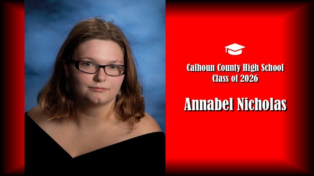  A formal senior portrait layout featuring a student with shoulder-length slightly wavy hair, wearing glasses and a black off-the-shoulder top, posed against a blue studio background on the left. The right side displays a bright red panel with a graduation cap icon and white text that reads “Calhoun County High School Class of 2026” and the name “Annabel Nicholas” in large bold letters. 