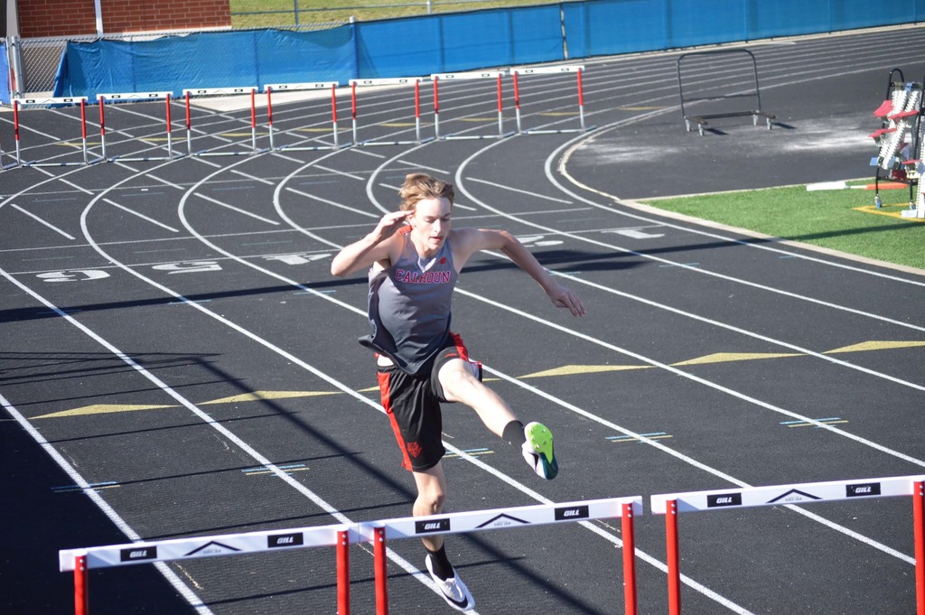 Male student doing hurdles