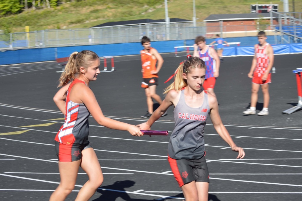 female runners passing the baton in relay