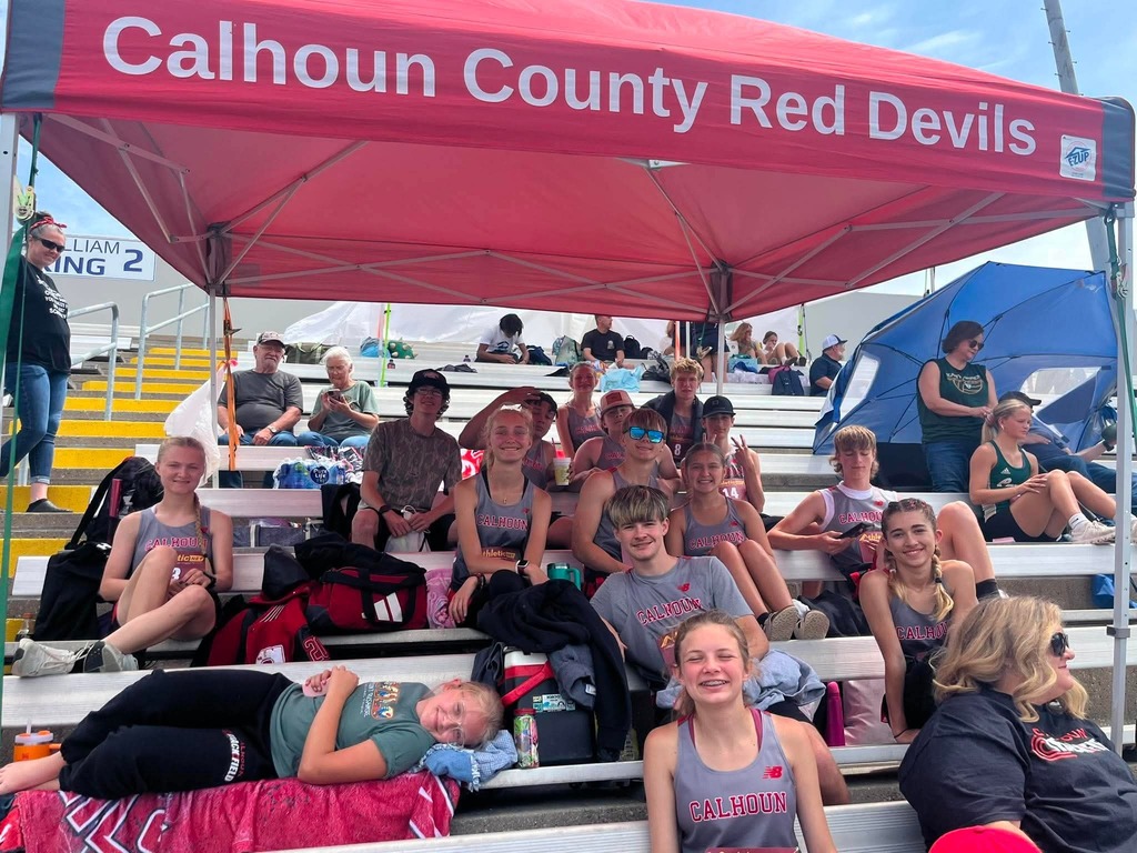 team members under red canopy that says Calhiun Red Devils 