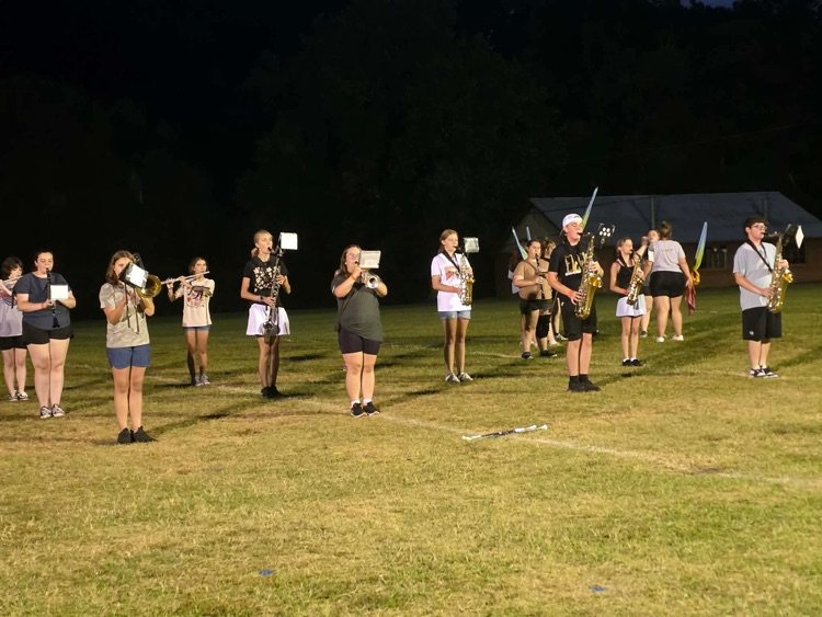 Students practicing at night on the field.