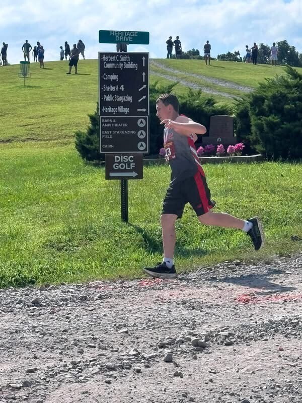 Silas Cunningham running on the gravel road at the county park