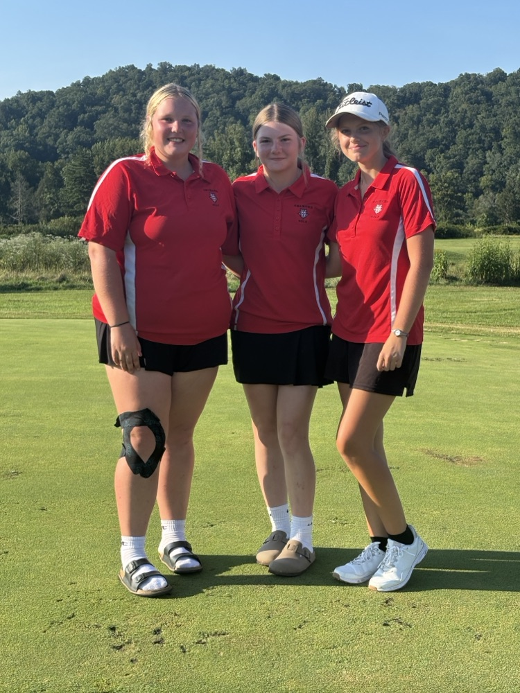 three girls in red on a golf course