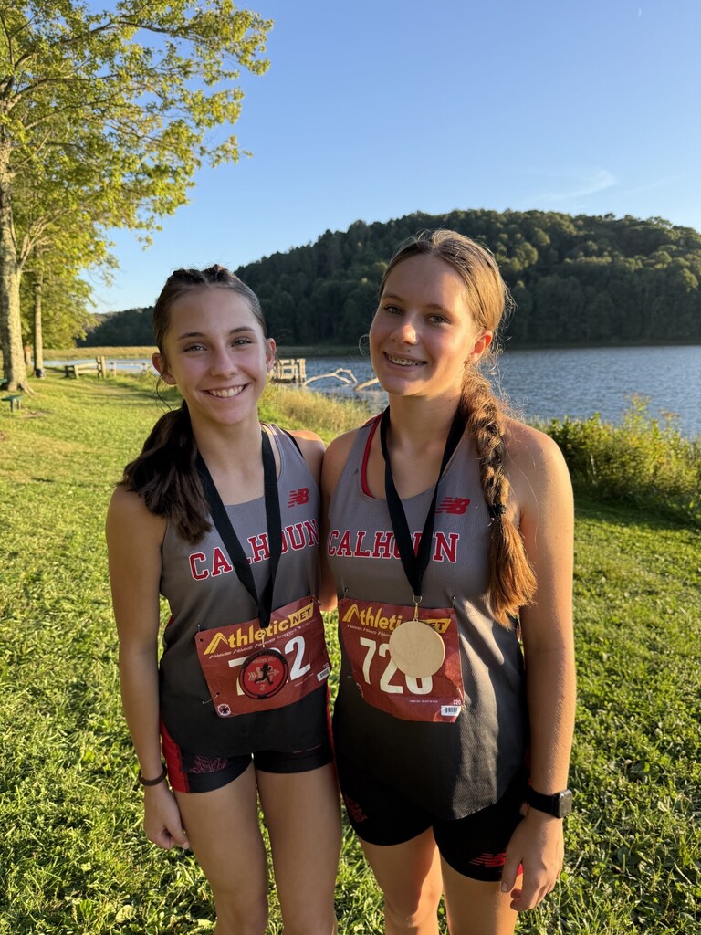 Brooke Tingler stands on left, Carissa Sands stands on right with medals. 