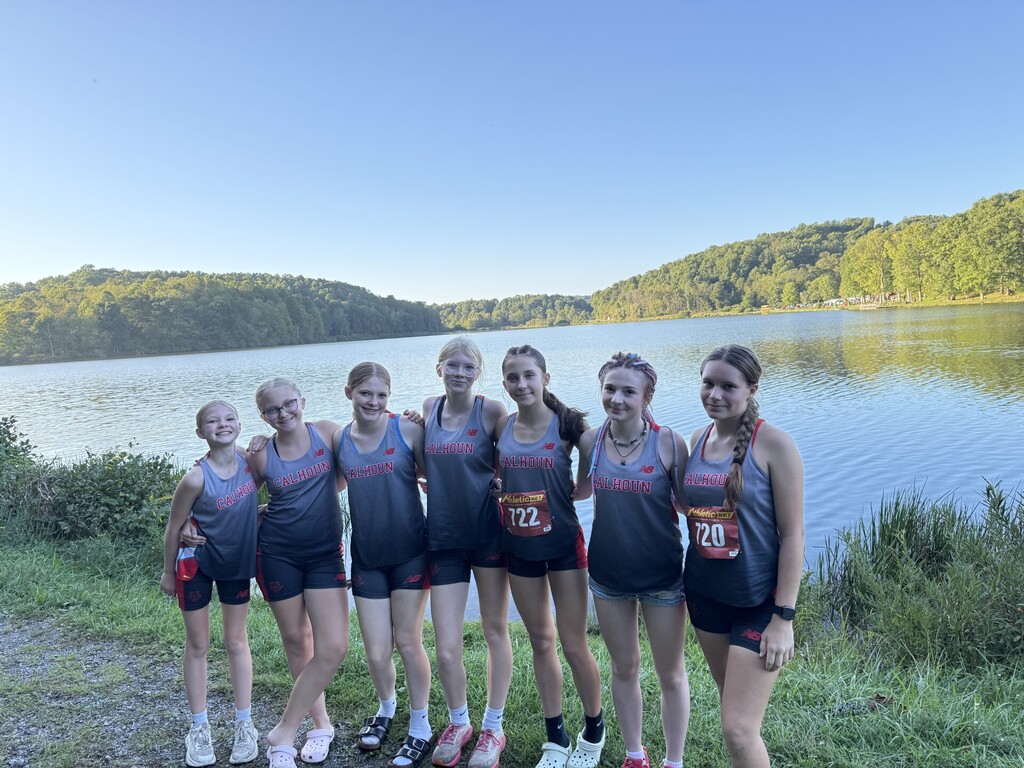 Cross County Girls stand in front of the lake