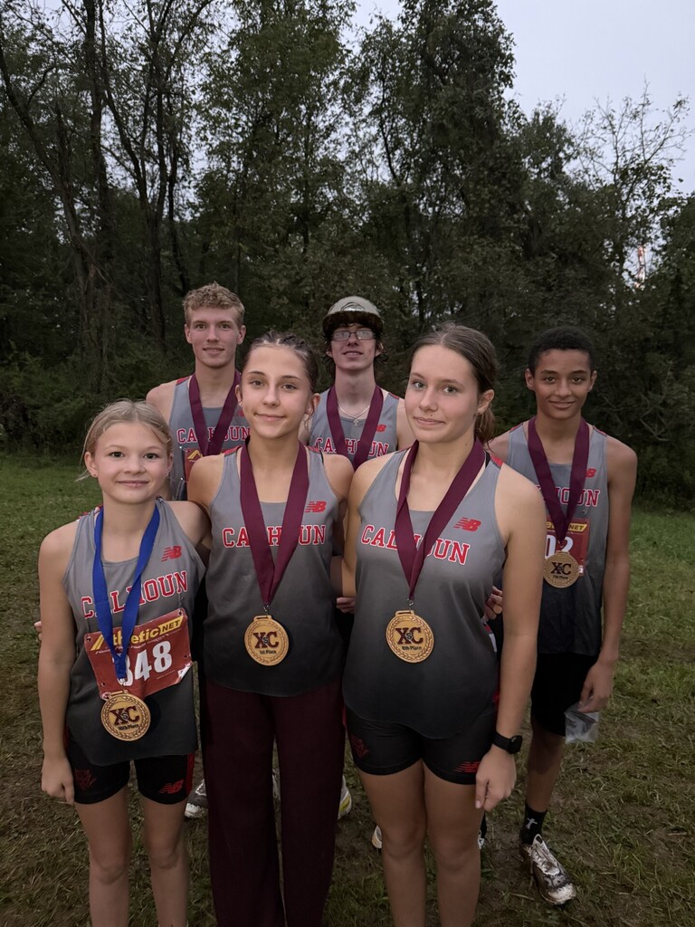 Six Winning team members pose with medals. 