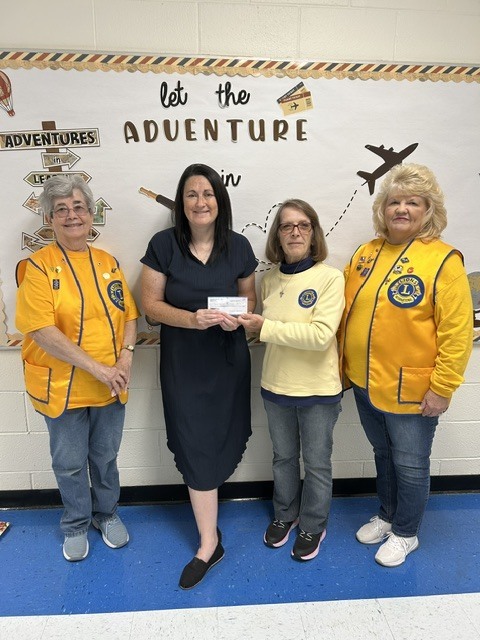 Mrs. Cunningham with members of the Grantsville Lions Club hold donation check