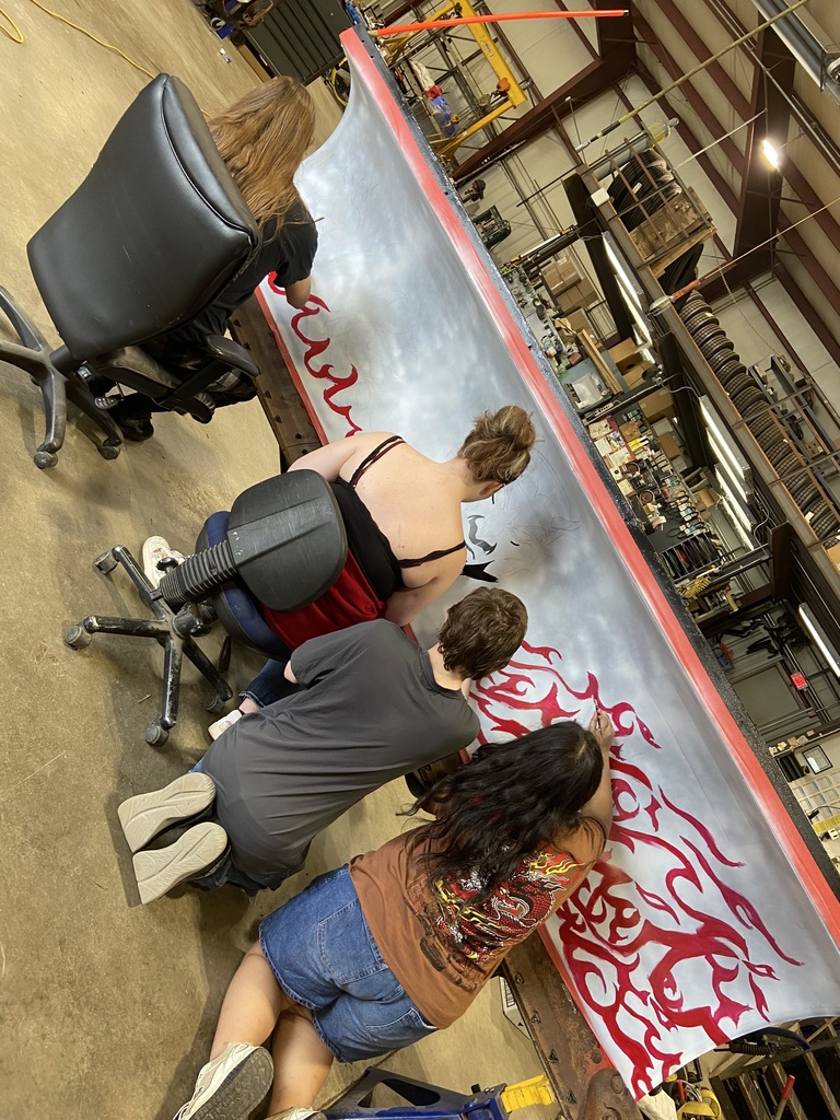 Students painting fire on snow plow