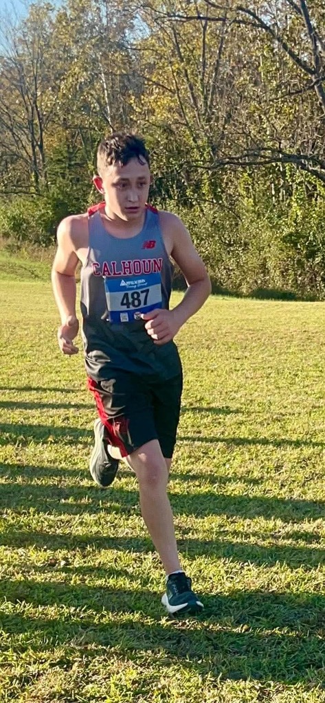 S Cunningham running with a field and trees behind him in the background