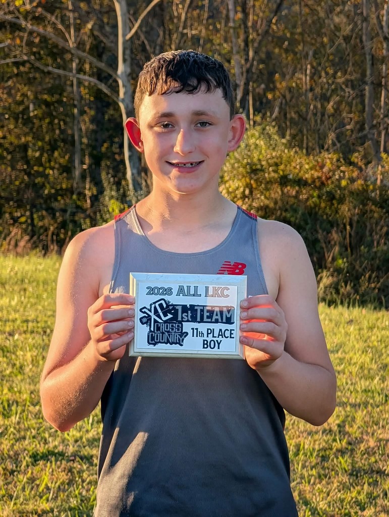 Silas Cunningham stands with his 1st team 11th place plaque.