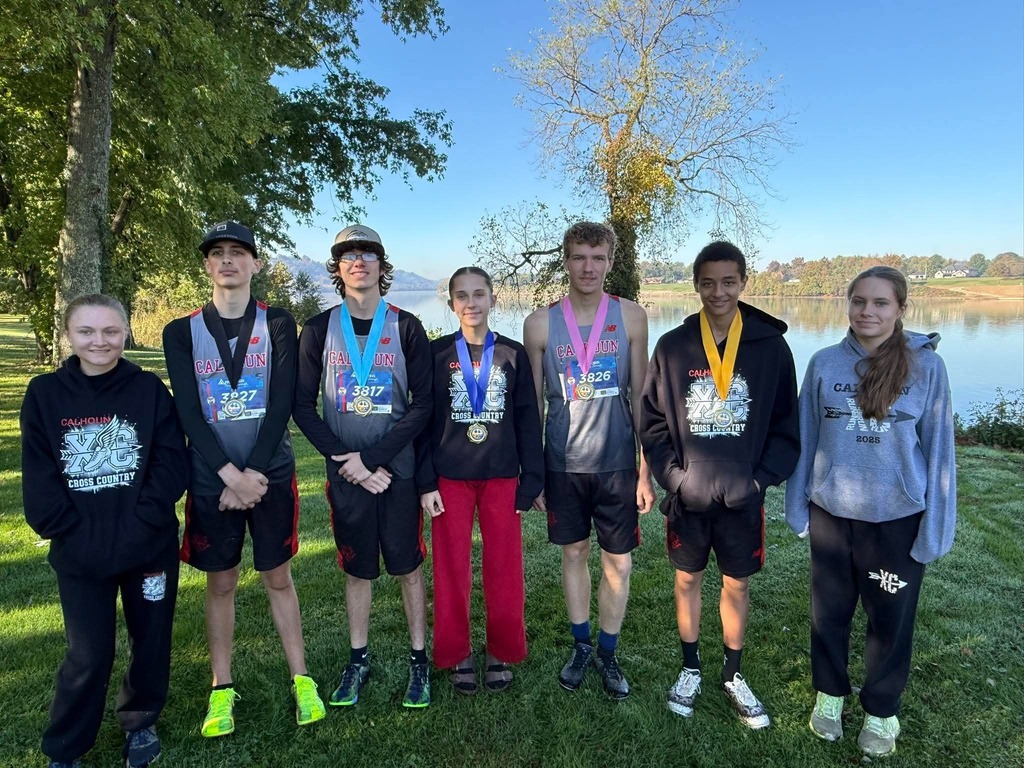 Group picture of students standing with medals with river behind them