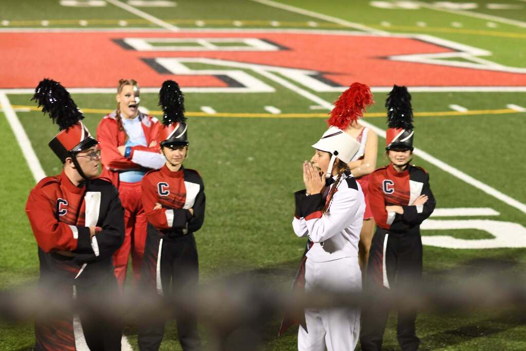 Band members stand on side line, and gasp in excitment when they hear their name called for Grant Champion