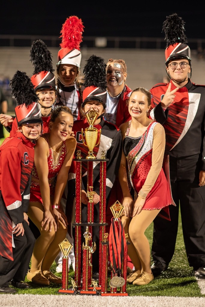 Band members dressed in red and black uniforms pose with the nights awards.