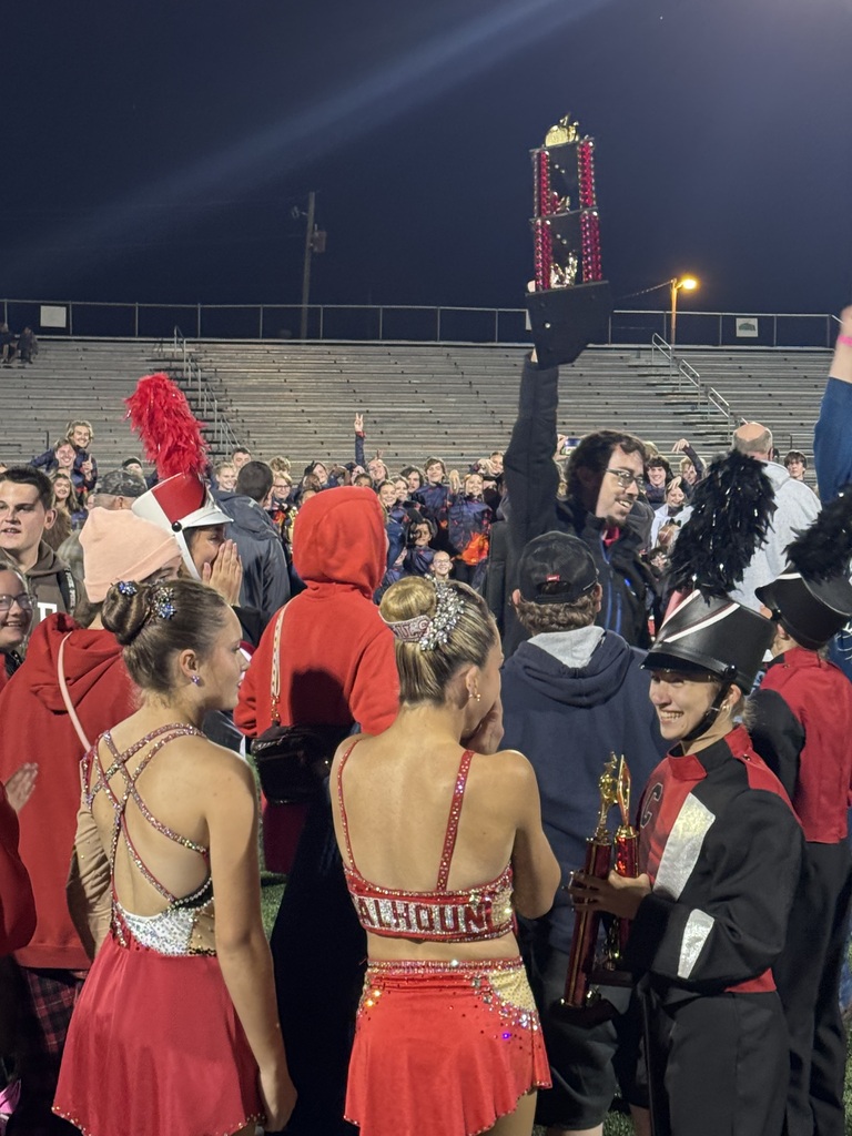 Mr. McHenry holds tropy in air with band members surrounding him