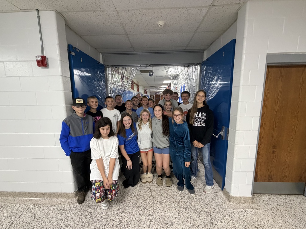 8th graders in their PJ's in the hallway they are decorating at the school.