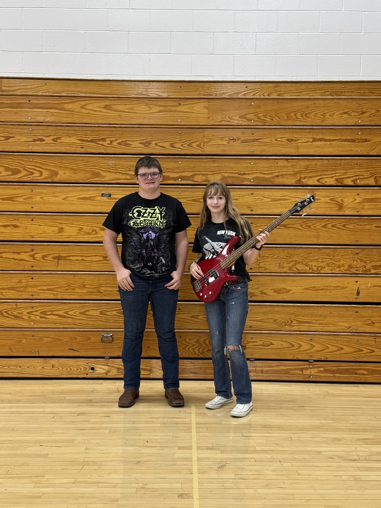 Sophomores dressed in their classic rock outfits the gym - Winner has on a black rock shirt, jeans and has a red guitar