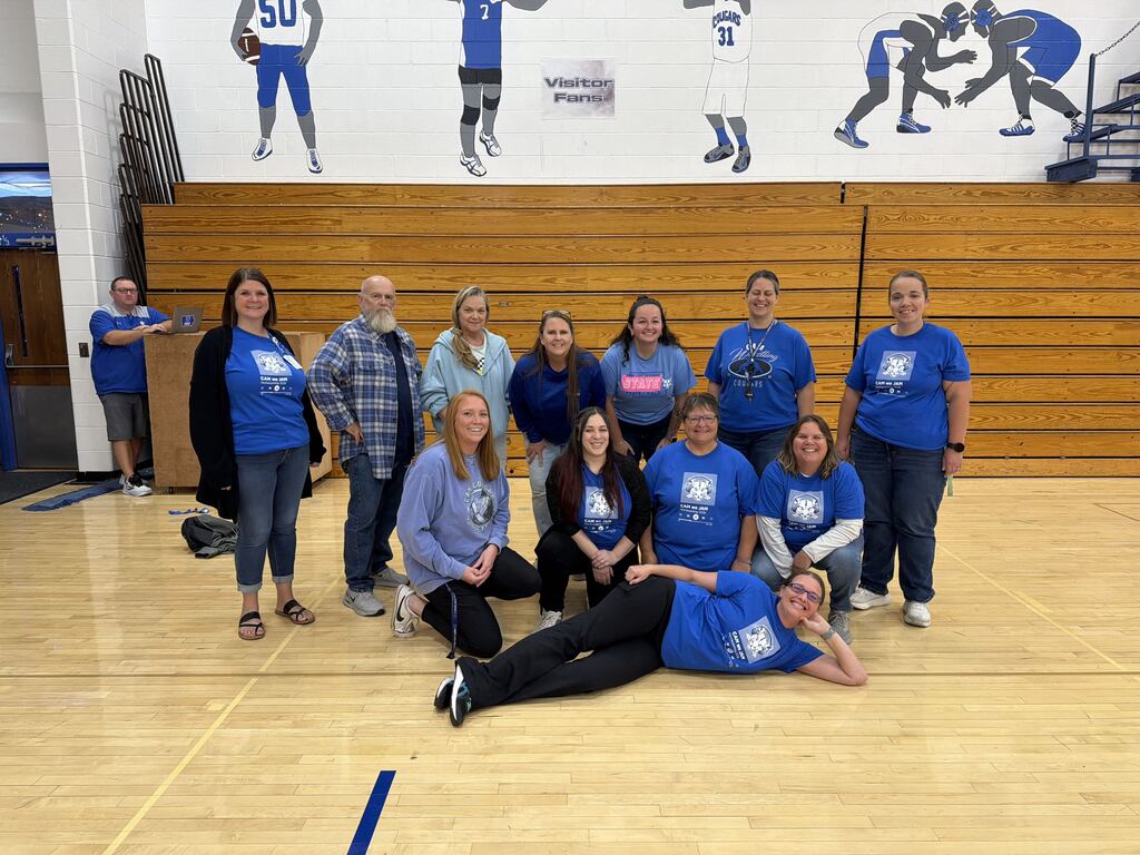 Staff members dressed in blue in the gym