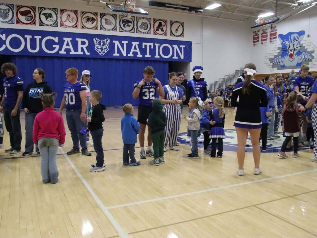 Senior class giving Kindergarteners a gift in the gym during the pep rally