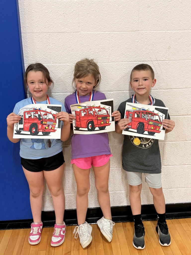 Three CAM students wearing medals display coloring pages of red fire trucks carrying firefighters.