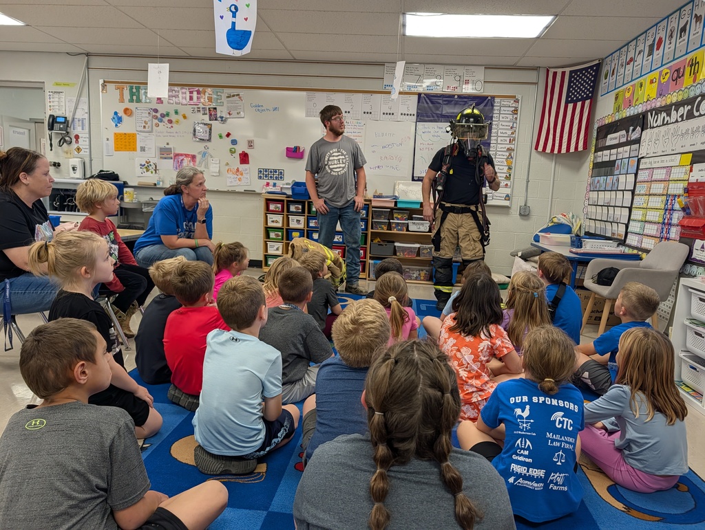 Firefighters showing first graders the gear they wear to keep safe.