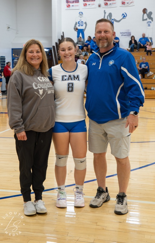 CAM volleyball senior poses with two family members on the gym court.