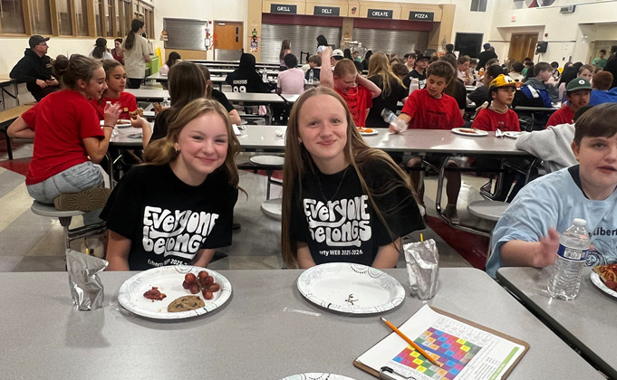 Two students posing at a table
