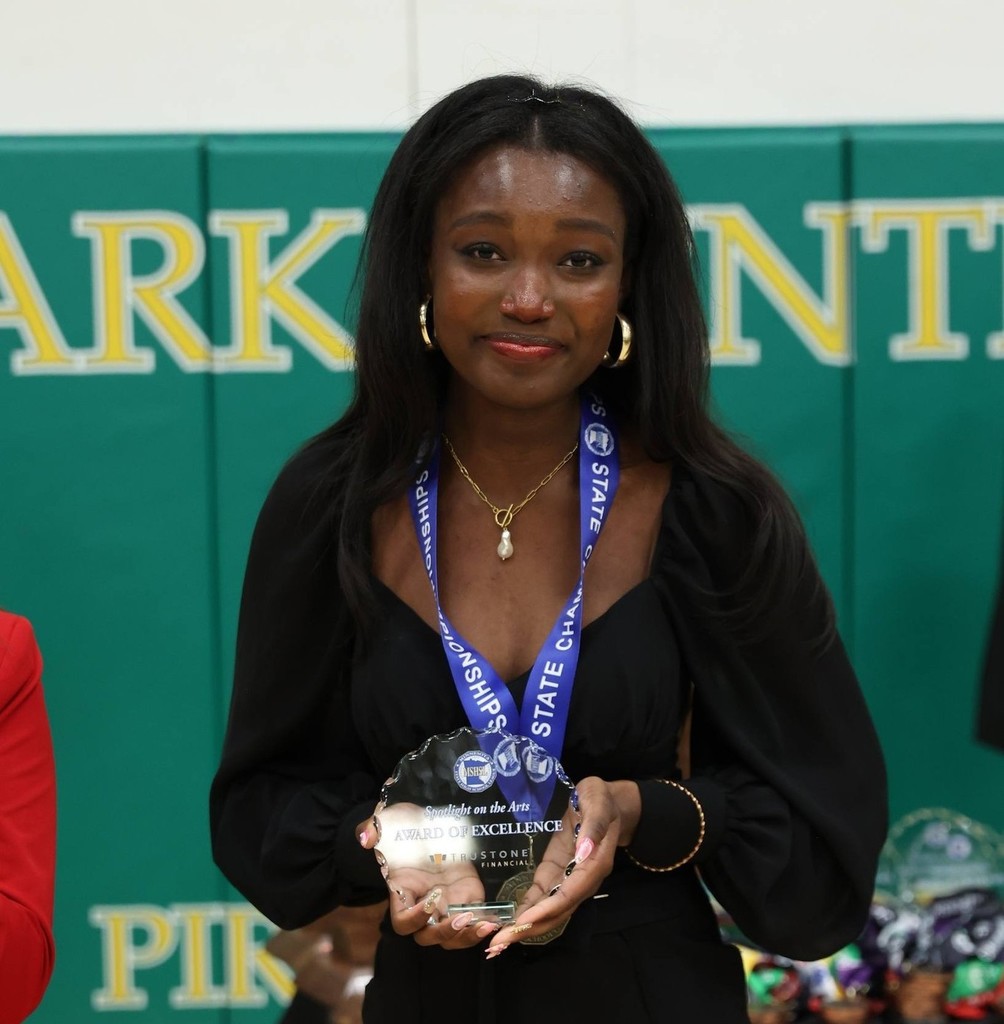 State Speech Champion holding her award.