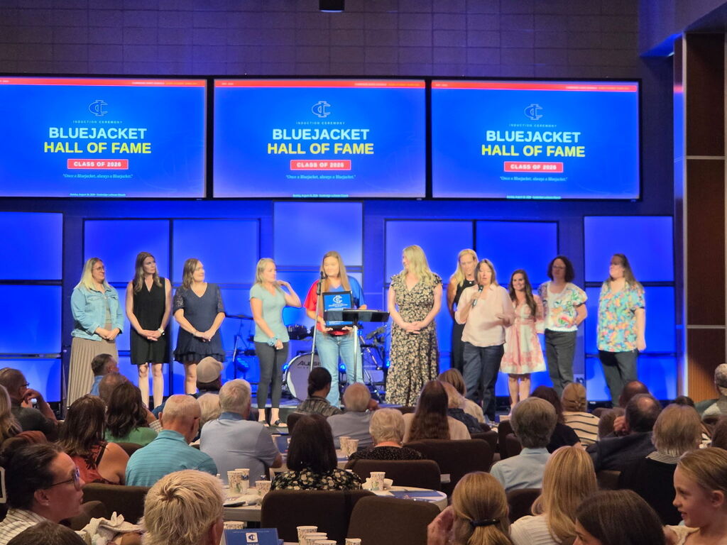 A group of award recipients stands on stage during the Bluejacket Hall of Fame Class of 2026 induction ceremony.
