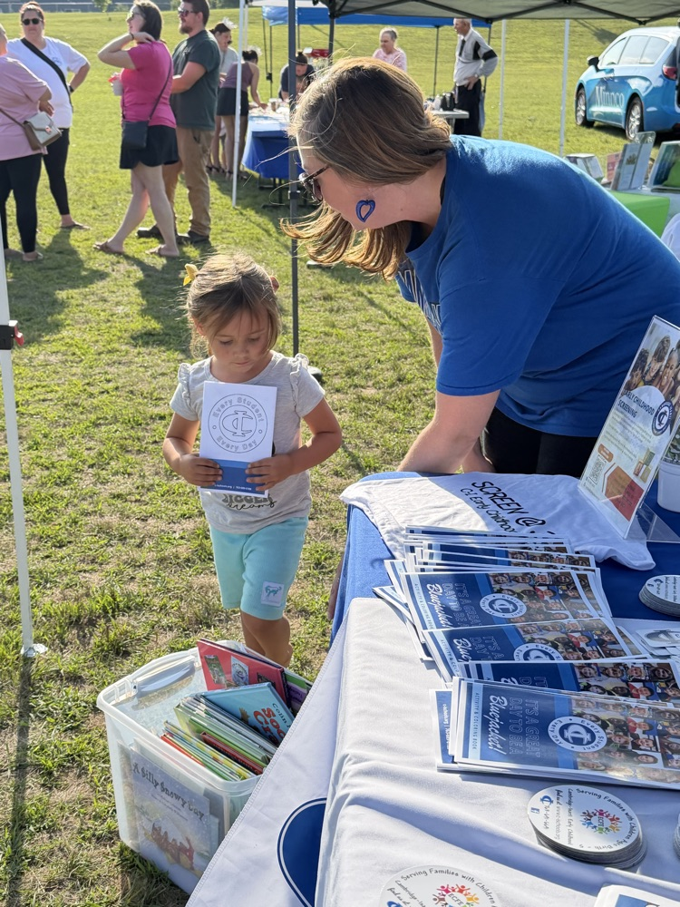Teacher showing books to a child 