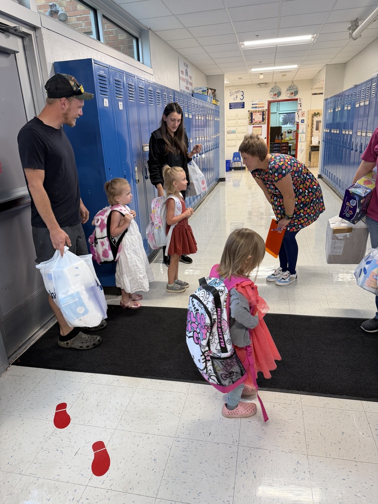 Families arriving at school for the first time, being greeted by staff