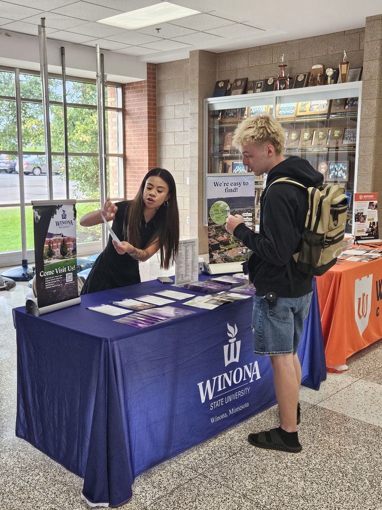 A student talks with a representative at a Winona State University table during a college fair.
