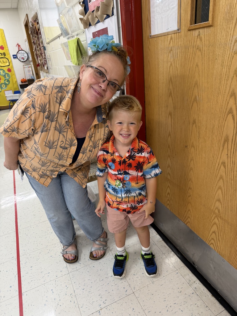 Staff and Student smiling and dressed in brightly colored Hawaiian shirts 