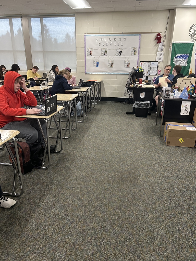 students in a classroom at desks catching up on schoolwork.