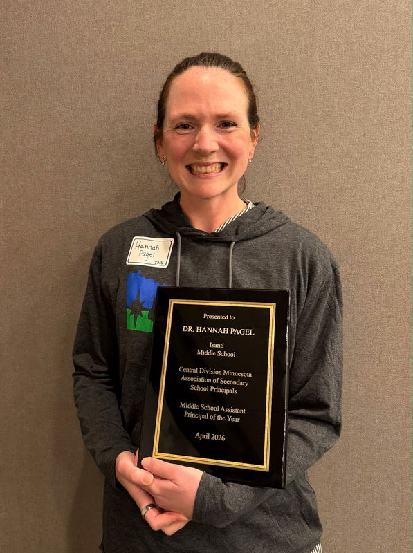 Dr. Hannah Pagel smiles while holding an award plaque recognizing her as Central Division Middle School Assistant Principal of the Year.