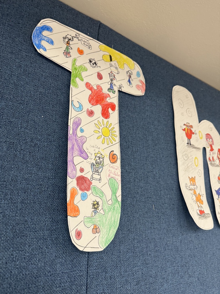 The letter "T" decorated with student art