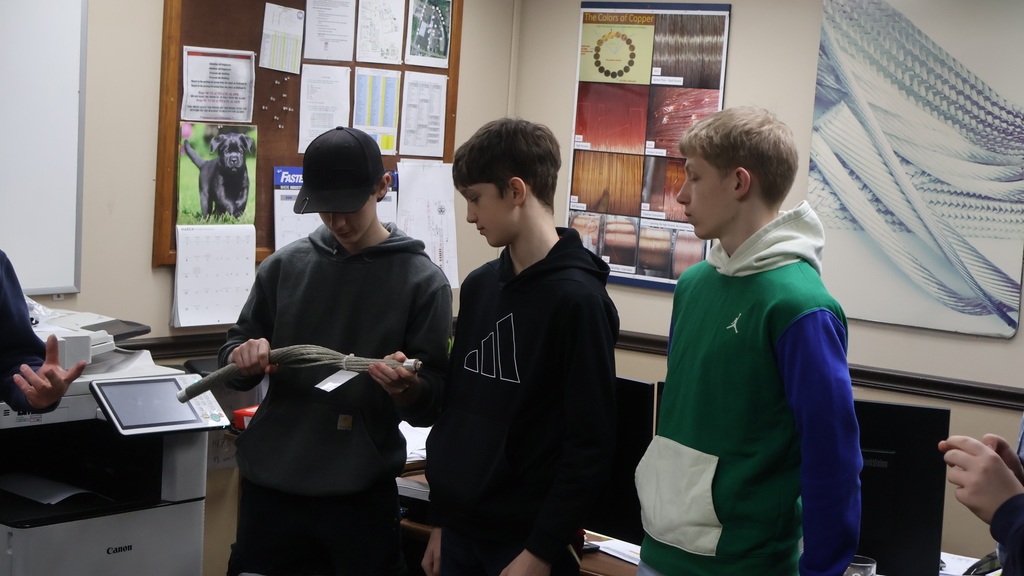 Three CHS students look at a wire sample from International Wire