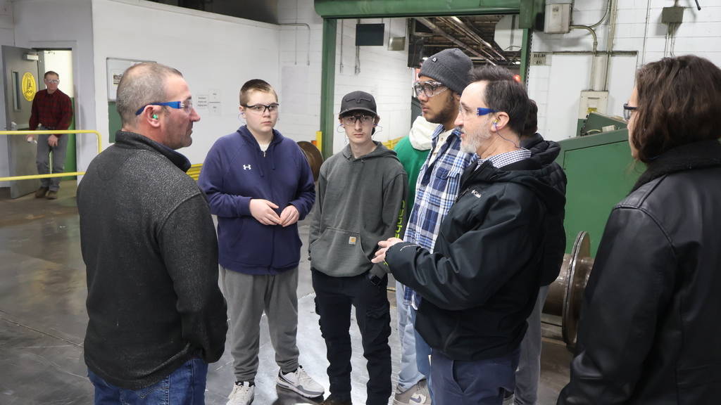 An IW Employee leads a group of students and Mr. Klepadlo through the tour at International Wire's factory floor