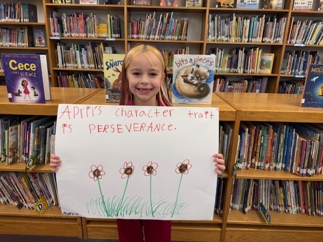 Student Holding Perseverance Poster