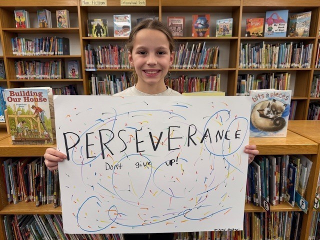 Student Holding Perseverance Poster