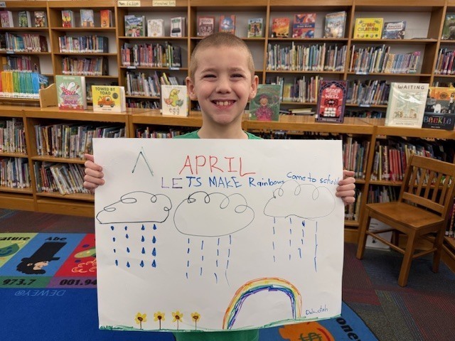 Student Holding Attendance Poster