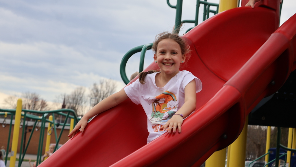 CES Students on Playground During Recess - Student on a large red slide