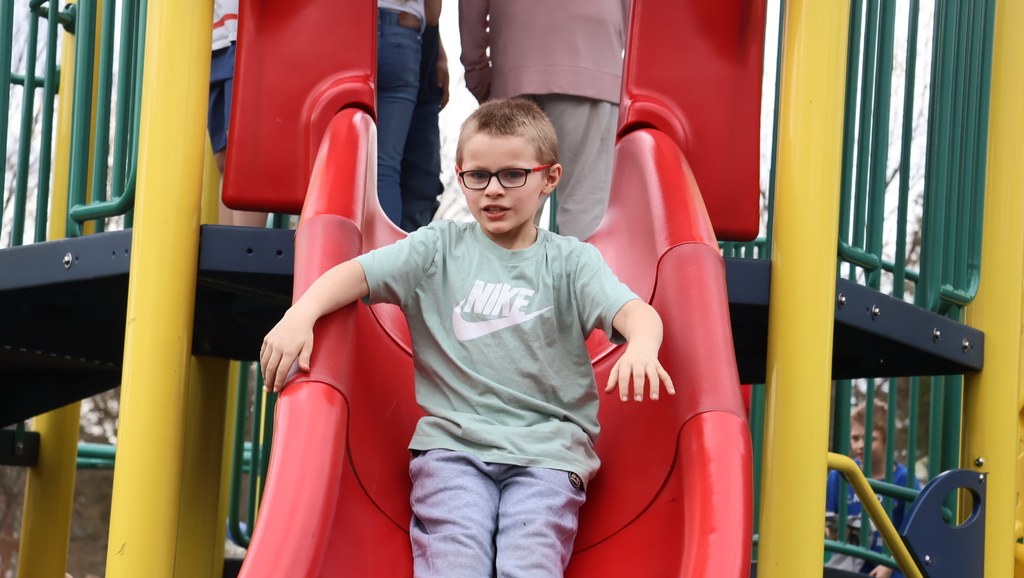 CES Students on Playground During Recess - Student on a large red slide