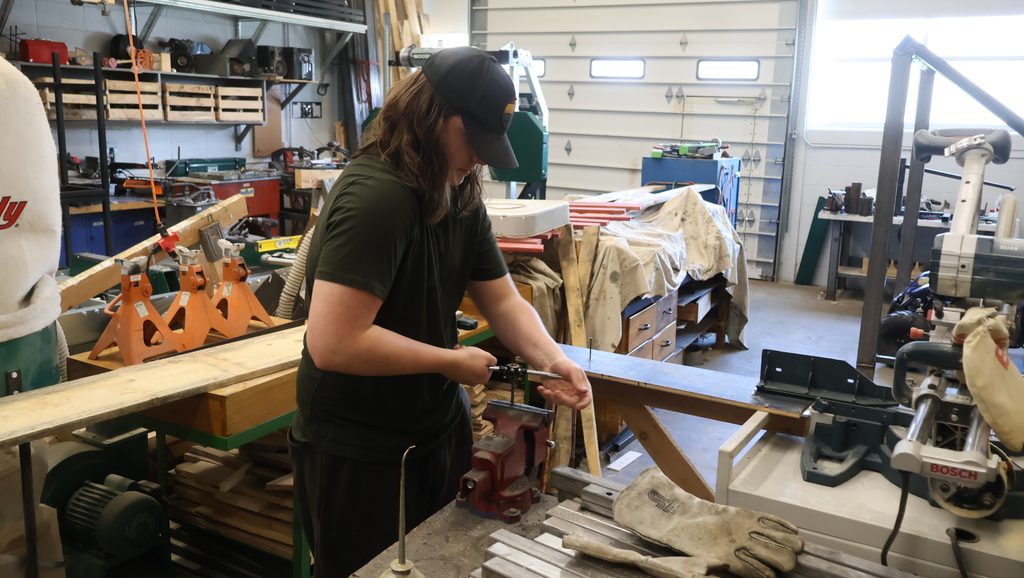 A student works at a vise. 