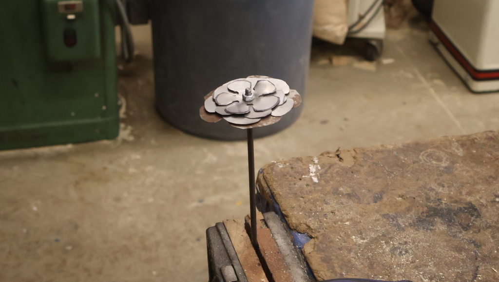 A flower in a vise, ready to be bent into shape. 