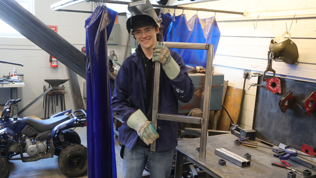 student holding up a set of welded table legs