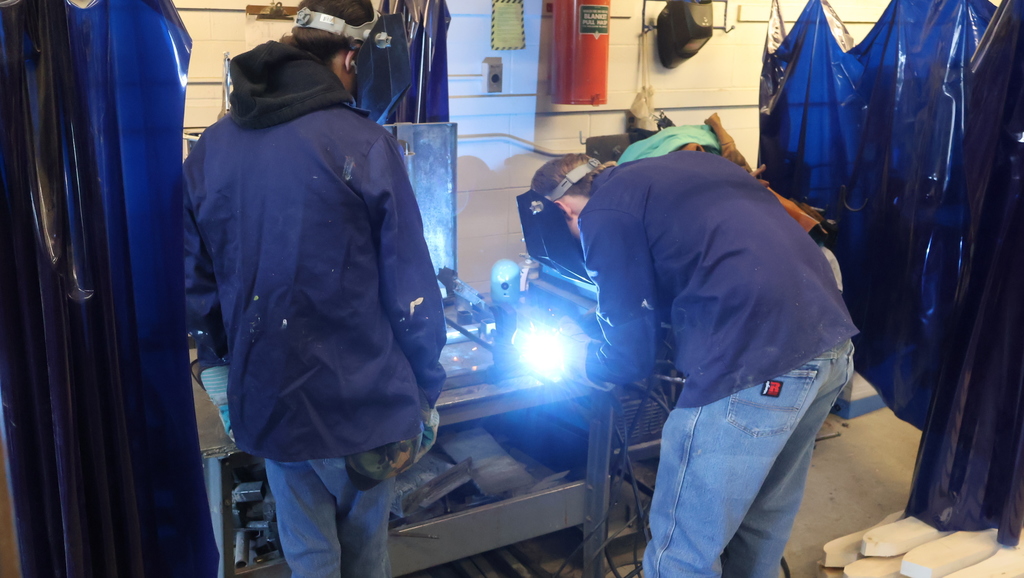 Students welding table legs together